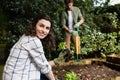 Smiling woman holding sapling plant in garden