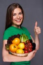 Smiling woman holding straw basket with summer vegetables Royalty Free Stock Photo
