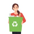 Smiling woman holding a trash can with plastic bottles: separate waste collection and recycling concept