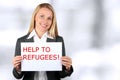 Smiling woman holding a white banner with words help to refugees