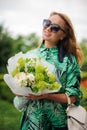 Smiling woman holds bouquet with white roses and green hydrangea. Royalty Free Stock Photo