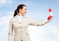 Smiling woman holds red handset phone on distance