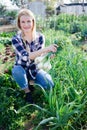 Smiling woman horticulturist holding harvest of green onion