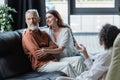 smiling woman hugging serious husband sitting