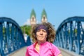 Smiling woman jogging across an urban bridge