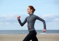 Smiling woman jogging at the sea side Royalty Free Stock Photo