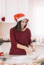 Smiling woman kneading cookie dough on kitchen bar