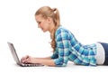 Smiling woman with laptop computer lying on floor Royalty Free Stock Photo