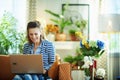 Smiling woman with laptop in modern living room in sunny day Royalty Free Stock Photo