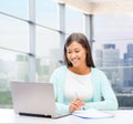 Smiling woman with laptop and notebook Royalty Free Stock Photo