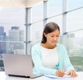 Smiling woman with laptop and notebook Royalty Free Stock Photo