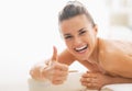 Smiling woman laying on massage table and showing thumbs up Royalty Free Stock Photo