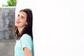 Smiling woman leaning against white wall looking up Royalty Free Stock Photo