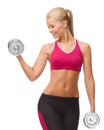 Smiling woman lifting steel dumbbell