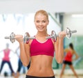 Smiling woman lifting steel dumbbells