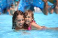 Smiling woman and little girl bathes in pool