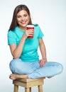 Smiling woman with long hair sitting on chair with coffee cup