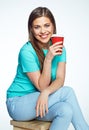 Smiling woman with long hair sitting on chair with coffee cup