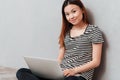 Smiling woman looking camera while working and holding laptop Royalty Free Stock Photo