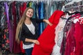 Smiling woman looking for dress in garment store Royalty Free Stock Photo