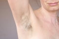 Smiling woman looking at her hairy unshaven armpit. Body positive and feminism concept, need to shave or depilation