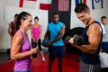 Smiling woman looking at male athlete lifting dumbbell Royalty Free Stock Photo