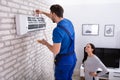 Technician Repairing Air Conditioner With Digital Multimeter Royalty Free Stock Photo