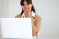 Smiling woman looking at you and using her laptop Royalty Free Stock Photo