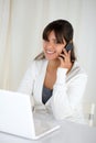 Smiling woman looking at you and using her laptop Royalty Free Stock Photo