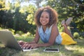 Smiling woman lying on grass and using laptop Royalty Free Stock Photo