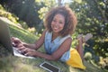 Smiling woman lying on grass and using laptop Royalty Free Stock Photo