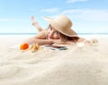 Smiling Woman lying on sand beach with smartphone, sunbathing with straw hat, concept of summer beach holiday and vacation travel Royalty Free Stock Photo