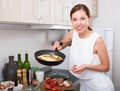 Smiling woman making omelet Royalty Free Stock Photo
