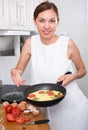 Smiling woman making omelet Royalty Free Stock Photo