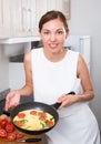 Smiling woman making omelet Royalty Free Stock Photo