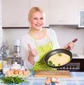 Smiling woman making omlet Royalty Free Stock Photo