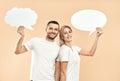 Smiling woman and man holding paper thought bubbles