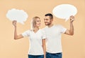 Smiling woman and man holding paper thought bubbles