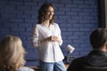 Smiling woman mentor give presentation to office employees Royalty Free Stock Photo