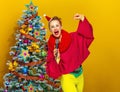 Smiling woman with microphone singing near Christmas tree Royalty Free Stock Photo