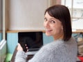 Smiling woman with mobile phone and laptop at home Royalty Free Stock Photo