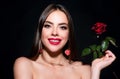 Smiling woman with naked shoulder red lips and rose flower. Fashion beauty portrait on studio black background. Royalty Free Stock Photo