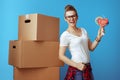 Smiling woman near cardboard box with tape dispenser on blue Royalty Free Stock Photo