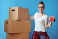 Smiling woman near cardboard box with tape dispenser on blue Royalty Free Stock Photo