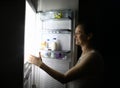 Smiling woman at night at home opened refrigerator Royalty Free Stock Photo