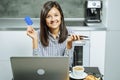 Smiling woman online shopping using a smartphone laptop and credit card at home Royalty Free Stock Photo
