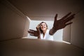 Smiling young woman opening a carton box, relocation and unpacking concept Royalty Free Stock Photo