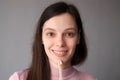 Smiling woman with organic bamboo toothbrush and toothpaste in her hands.