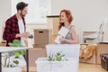 Smiling woman packing lamp into boxes during relocation to new home with husband Royalty Free Stock Photo