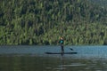 Smiling woman paddleboarding on the mountain lake